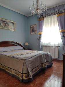 - une chambre avec un grand lit et un lustre dans l'établissement CASA LOS ABUELOS, à Navalmoral