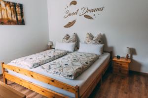 een slaapkamer met een bed met een bord met zoete dromen bij Feriendomizil-Sauerland FeWo 3 in Medebach