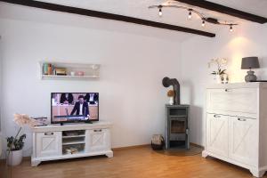 Ferienwohnung Bahnsen في Lügde: غرفة معيشة مع تلفزيون على خزانة بيضاء