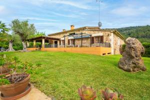 una vista exterior de una casa con un gran patio en Ca na Rossa, en Campanet