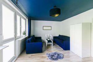 salon z 2 niebieskimi kanapami i stołem w obiekcie Apartament w Centrum III w Ustce
