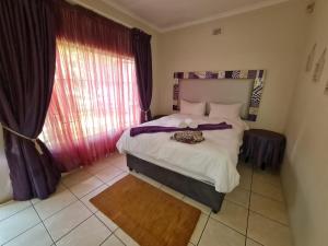 a bedroom with a large bed and a window at Sherwood Forest 2 Marina Drive in Southbroom +17 photos