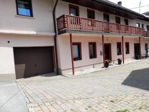 a house with a balcony and a garage at Hiša Pepi in Ajdovščina