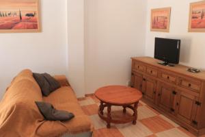 sala de estar con sofá y mesa pequeña en Apartamento San José Obrero, en Conil de la Frontera
