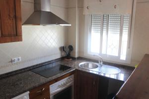 cocina con fregadero, fogones y ventana en Apartamento San José Obrero, en Conil de la Frontera