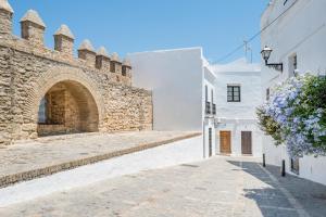 an alley in the side of a white building at Apartamento María in Vejer de la Frontera