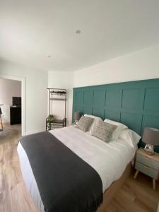 a bedroom with a large bed with a green headboard at Apartamentos Cañalío in Santander