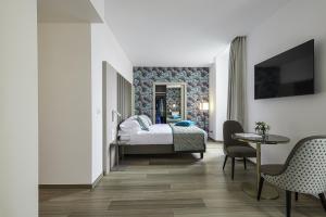 a bedroom with a bed and a table and chairs at Sublimis Boutique Hotel Adults-Only in Camogli