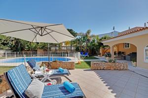 a patio with two chairs and an umbrella at Casa Helena in Quarteira