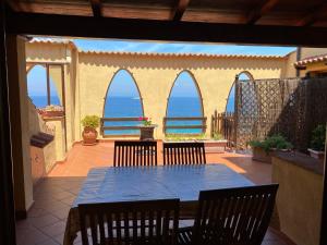 a patio with a table and chairs and the ocean at Le Ghiaie Relax in Portoferraio