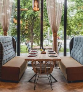 プロブディフにあるCity Park Innのテーブルと椅子と窓のあるダイニングルーム