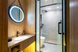 a bathroom with a sink and a mirror and a shower at 洛阳Travel World Hotel in Luoyang