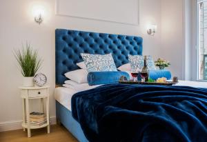 niebieskie łóżko z niebieskim zagłówkiem w sypialni w obiekcie Warsaw Seasons by Alluxe Boutique Apartments w Warszawie