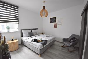 a bedroom with a bed and a chair at Apartmány Ve stodole in Roudnice nad Labem