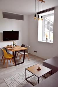 a living room with a table and a couch at Apartmány Ve stodole in Roudnice nad Labem