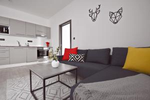 a living room with a blue couch and a table at Apartmány Ve stodole in Roudnice nad Labem
