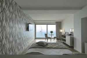 a bedroom with a bed and a table with a view of the ocean at Sublimis Boutique Hotel Adults-Only in Camogli