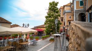 una calle vacía con mesas, sillas y sombrillas en Castellabate Apartments Casa Cardone en Castellabate