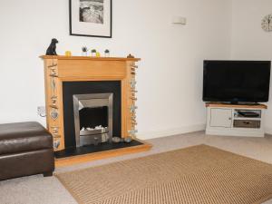 a living room with a fireplace and a television at Atlantic View in Bude