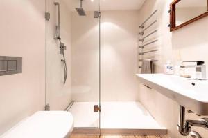 uma casa de banho com um chuveiro, um WC e um lavatório. em Residence Au Reduit Sankt Moritz em St. Moritz
