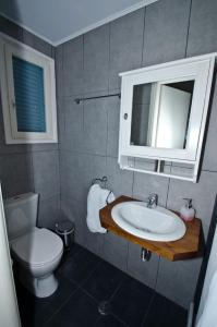 a bathroom with a sink and a toilet and a mirror at MarKaMar in Loutraki