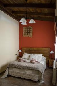a bedroom with a large bed with red walls at Vivienda Turistica El Caneco in Tordesillas