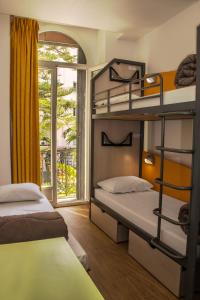 two bunk beds in a room with a window at Auberge de Jeunesse HI Nice Les Camélias in Nice