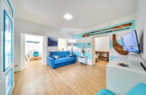een woonkamer met een blauwe bank en een tv bij El Lavandee in Varenna