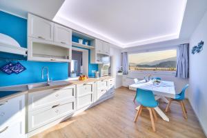 een keuken met blauwe muren en een tafel en stoelen bij El Lavandee in Varenna