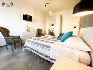 - une chambre avec un lit, une chaise et une télévision dans l'établissement 4 Balconi rooms-Elements B&B, à Lecce