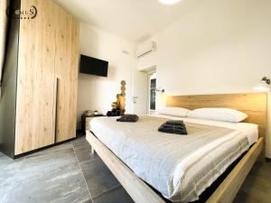 - une chambre avec un grand lit et une tête de lit en bois dans l'établissement 4 Balconi rooms-Elements B&B, à Lecce