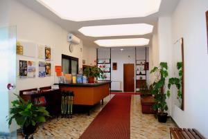 an office lobby with a reception desk and potted plants at Hotel Bristol in Laigueglia