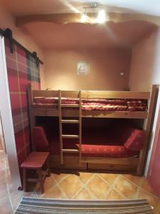 a room with two bunk beds and a chair at Prato Nevoso Borgo Stalle Lunghe con accesso diretto alle piste da sci in Prato Nevoso