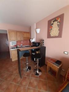 a kitchen with a table and two bar stools at Prato Nevoso Borgo Stalle Lunghe con accesso diretto alle piste da sci in Prato Nevoso