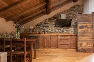 una cocina con armarios de madera y una pared de piedra. en Apartamentos Rurales Casa Llongo en Coaña