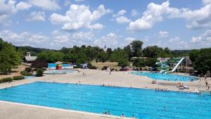 a large swimming pool in a park with people in it at Dada House Nature Holiday in Gornja Čemernica