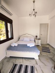 a bedroom with a bed and a window and a chandelier at Via Ferrata Houses in Kalymnos