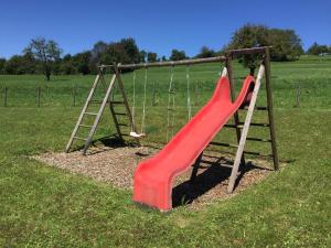 a playground with a red slide and a ladder at Ferienwohnung Mara in Öhningen