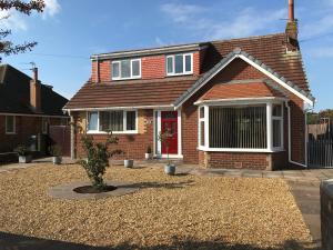 a red brick house with a red door at 24 Elmhurst Road in Lytham St Annes