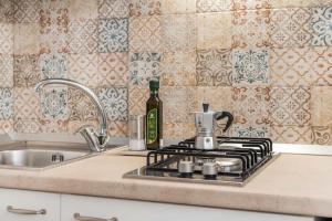 a kitchen counter with a stove and a sink at Palazzo Borgomonte - holiday home in Otranto
