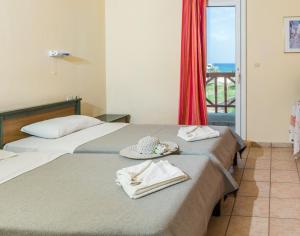 a hotel room with two beds and a balcony at Elina Apartments Gouves in Gouves