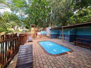a swimming pool on a brick patio with a playground at Sherwood Forest 2 Marina Drive in Southbroom