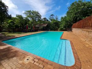 a swimming pool with blue water in a yard at Sherwood Forest 2 Marina Drive in Southbroom