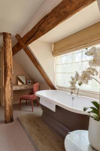 a attic bathroom with a tub and a window at The Falstaff in Canterbury in Canterbury