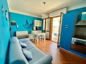 een blauwe woonkamer met een bank en een tafel bij Residenza le quattro palme in Alghero +29 foto's