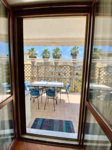 een terras met een tafel en stoelen bij Residenza le quattro palme in Alghero