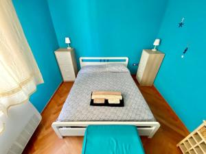 een kleine slaapkamer met een bed en blauwe muren bij Residenza le quattro palme in Alghero