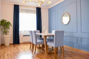 une salle à manger avec des murs bleus, une table et des chaises dans l'établissement NIDEHO Estate Apartmani, à Zlatibor