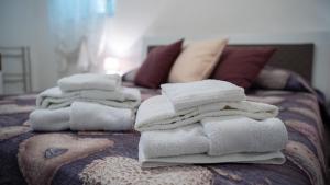 a pile of towels sitting on top of a bed at Castellabate Apartments Casa Ronna Rosa in Santa Maria di Castellabate
