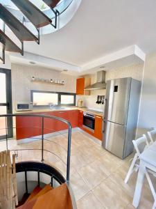 a kitchen with orange cabinets and a stainless steel refrigerator at Wave & Chill -The House- in Cotillo